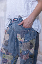 Load image into Gallery viewer, Very baggy jeans with a lot of patches Front view up very close 
